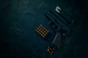 Pistol and bullets on concrete table. photo