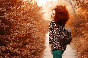 mujer con afro camina en el parque en otoño