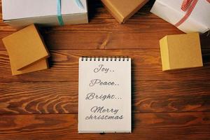 Top view of spiral notebook and gift boxes on wood table background. photo