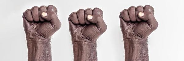 Male hands clenched into a fist on a white background. A symbol of the struggle for the rights of blacks in America. Protest against racism.Banner. photo