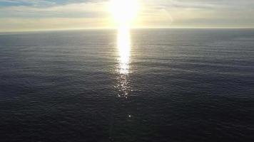 Toma aérea de la puesta de sol sobre un horizonte de playa y océano.