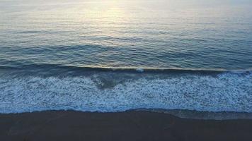 ripresa aerea del sole che tramonta su un orizzonte di spiaggia e oceano. video