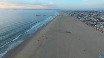 Toma aérea de una pintoresca ciudad de playa y mar al atardecer. video