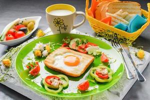 Egg in toast bread baked in the shape of a flower with fresh vegetables and yogurt photo