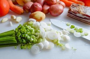 Spring vegetables and bacon on the kitchen table.Healthy foods are on the table. Homemade food preparation. photo