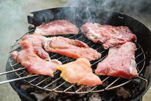 Grilled meat, pork, beef and chicken meat on barbecue, grill. Shallow depth of field. photo