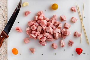 Raw meat, sliced pork steaks on kitchen  table. Meat processing. Skewers preparation. photo