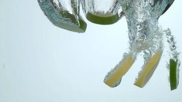 Lemon and lime slices splashing into water in slow motion shot on Phantom Flex 4K at 1000 fps video