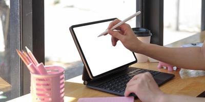 Close up of woman holding new version digital tablet device in hands with a smart pencil photo