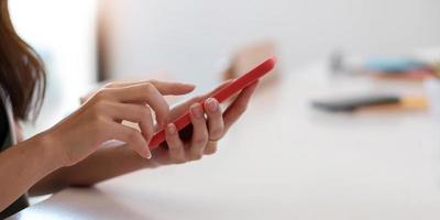 Close up of woman holding smartphone, typing message, texting, chatting, female hands using cellphone, browsing mobile apps, internet, checking social networks, email, playing games on the phone photo
