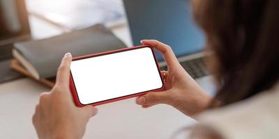 Close up of person holding a cell phone with a white blank screen photo