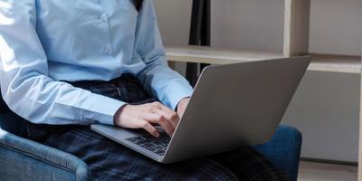 mujer usando laptop en un loft studio, estudiante investigando trabajo de procesamiento foto