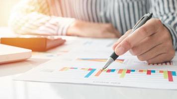 Businesswoman using a calculator and writing notes. Taxes, savings, finances, and economy concept photo