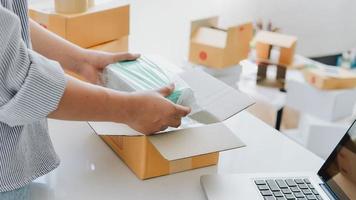 Closeup view of female's online store, small business owner seller, entrepreneur packing package, post shipping box preparing delivery parcel on the table, entrepreneurial self-employed business concept photo