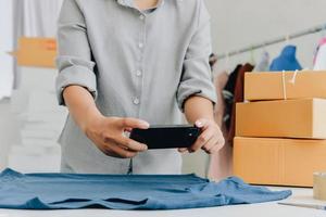 Closeup view of female's online store, small business owner seller, entrepreneur packing package, post shipping box preparing delivery parcel on the table, entrepreneurial self-employed business concept photo