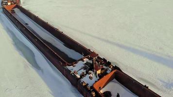 Old ship barge on a frozen river aerial shooting video