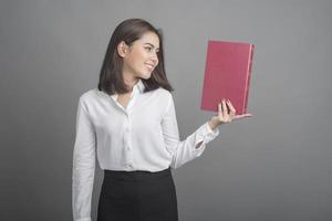 Beautiful teacher Woman holding book on grey background photo