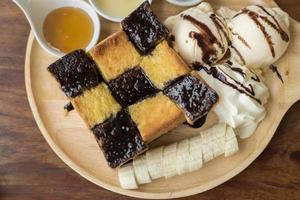 tostada de miel con helado de vainilla, nata montada y sirope de chocolate. servido con banana foto