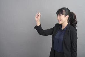 Beautiful Business Woman writing something on grey background photo