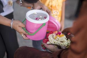 Water in water dipper with colorful flowers pedestal for Songkran festival, Thailand photo