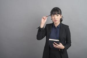 Beautiful Business Woman thinking on grey background photo