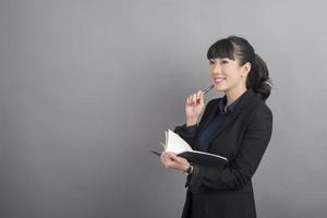 Beautiful Business Woman thinking on grey background photo