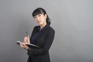 hermosa mujer de negocios pensando en fondo gris foto