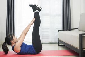 Beautiful Young sporty woman exercising at home photo