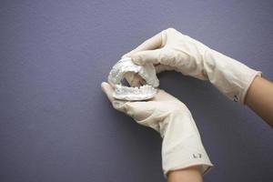 Dentist hand with plaster model photo