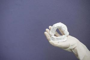 Dentist hand with plaster model photo