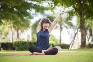 Beautiful yoga woman on green park photo