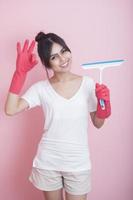 Beautiful asian housewife smiling on pink background photo