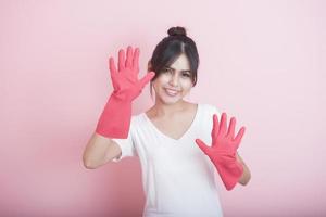 Hermosa ama de casa asiática sonriendo sobre fondo rosa foto