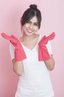 Beautiful asian housewife smiling on pink background photo