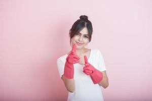 Hermosa ama de casa asiática sonriendo sobre fondo rosa foto