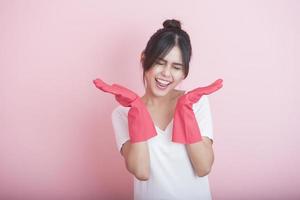 Hermosa ama de casa asiática sonriendo sobre fondo rosa foto