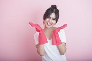 Hermosa ama de casa asiática sonriendo sobre fondo rosa foto