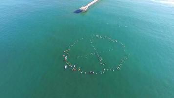 Toma aérea de surfistas remando para protestar en el océano. video
