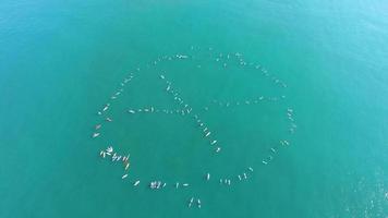 luchtfoto van surfers die op de oceaan peddelen om te protesteren. video