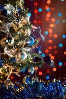 Adornos navideños en la rama de un árbol sobre fondo bokeh foto