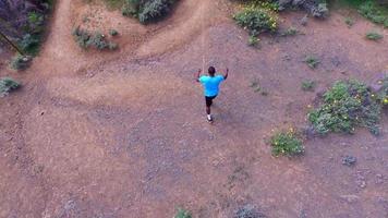 ripresa aerea di un sentiero di giovane uomo che corre su un sentiero panoramico. video
