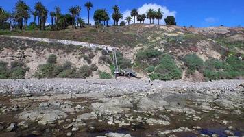 antennskott av en ung man som kör trappor på sidan av en klippa vid havet. video