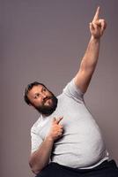 Happy handsome bearded excited man in gray t-shirt with hands up celebrating photo