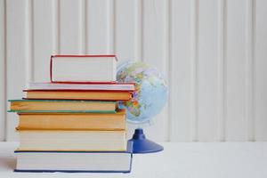 Stacks of educational books and the globe on a white background. Education concept. photo