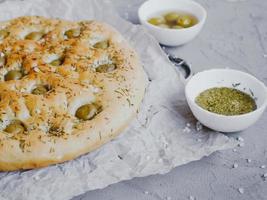 Traditional Italian focaccia bread with olives, rosemary, salt and olive oil. Homemade focaccia. photo