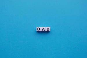 Dad word cubes on a blue background photo
