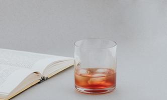 whisky y libro, leyendo en un ambiente acogedor con una buena bebida foto