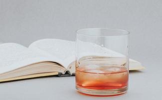 whisky y libro, leyendo en un ambiente acogedor con una buena bebida foto