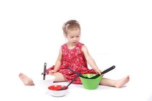 niño pequeño usando accesorios de cocina divirtiéndose foto