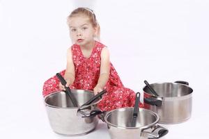 niño pequeño usando accesorios de cocina divirtiéndose foto